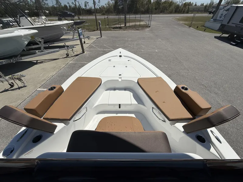 Slide: The Image of 2025 Sea Pro 230 Bay boat with tan seating, docked in a marina. - 6
