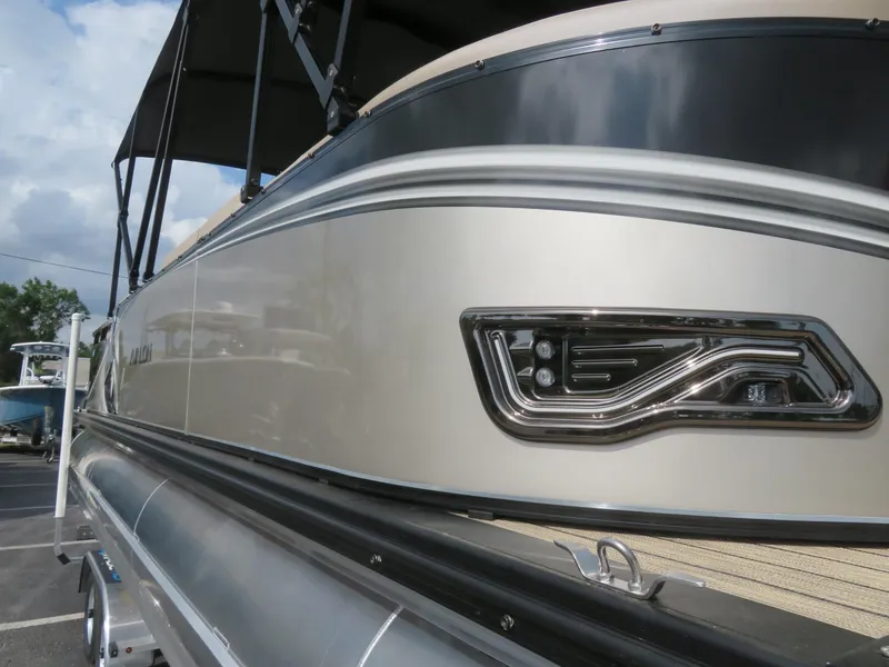 Slide: The Image of 2025 Avalon LSZ Quad Lounger boat, sleek design, close-up view, outdoor setting. - 11