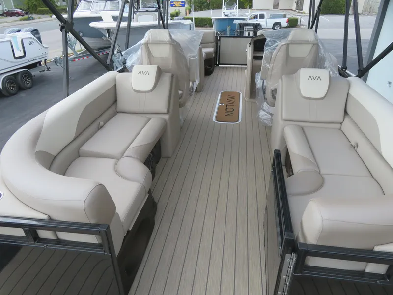 Slide: The Image of 2025 Avalon LSZ Quad Lounger boat interior with beige seating and wood-style flooring. - 18