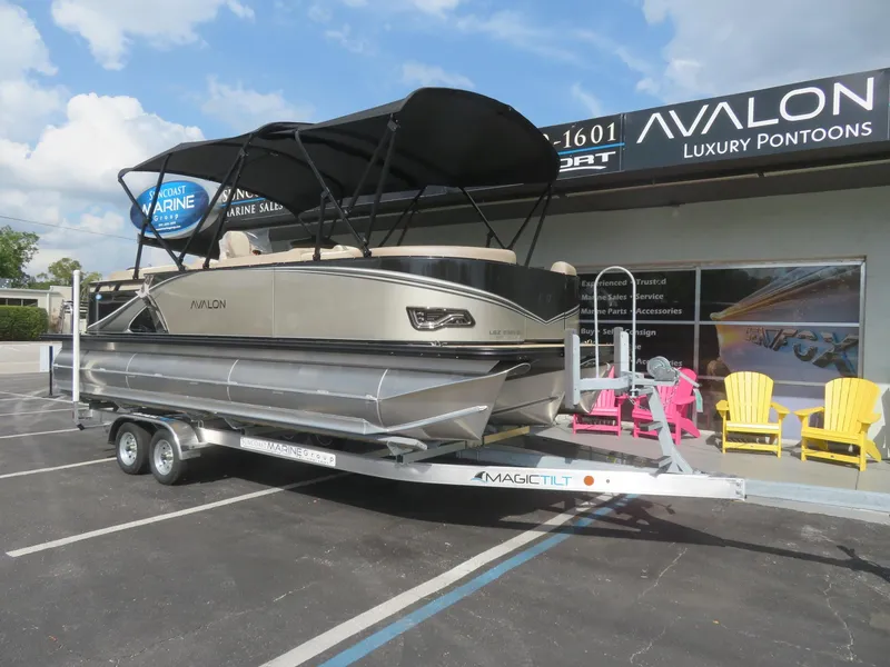 Slide: The Image of 2025 Avalon LSZ Quad Lounger pontoon boat on trailer at dealership. - 2