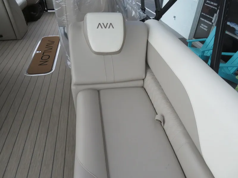 Slide: The Image of 2025 Avalon LSZ Quad Lounger boat seat with beige upholstery and logo. - 20