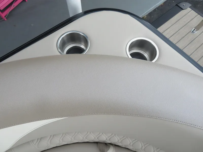 Slide: The Image of Avalon LSZ Quad Lounger 2025 boat interior with cup holders and beige seating. - 26