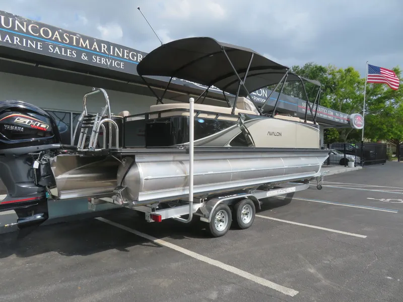 Slide: The Image of 2025 Avalon LSZ Quad Lounger pontoon boat on trailer at marine dealership. - 5