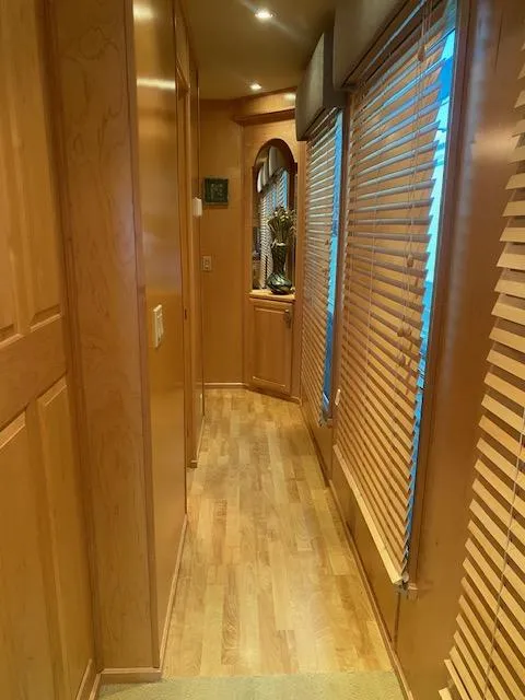 Slide: The Image of 2007 Sharpe 18 x 84 houseboat interior hallway with wooden flooring and blinds. - 12
