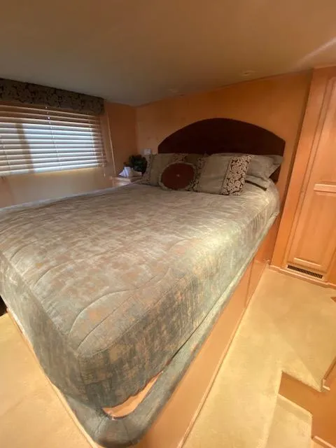 Slide: The Image of 2007 Sharpe 18 x 84 Houseboat bedroom with cozy bed and wooden interior. - 13