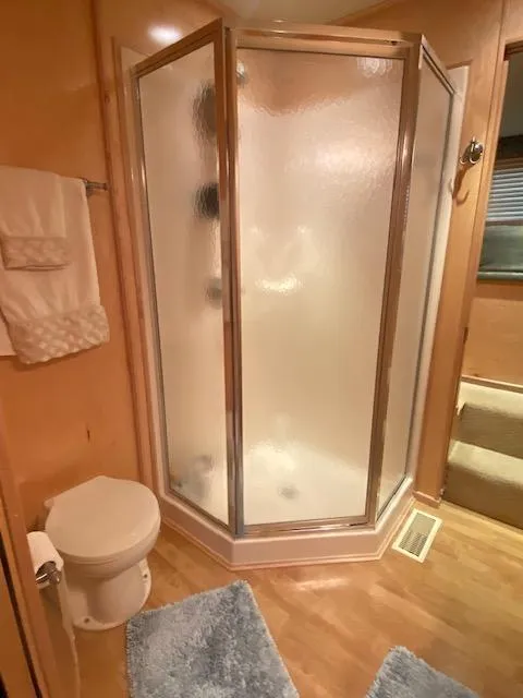 Slide: The Image of Bathroom in 2007 Sharpe 18 x 84 Houseboat with shower, toilet, and blue rugs. - 20