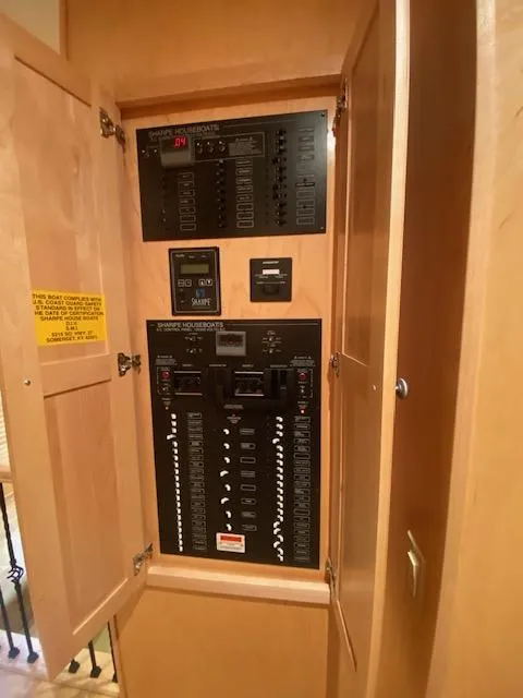 Slide: The Image of Electrical panel inside a 2007 Sharpe 18 x 84 houseboat, featuring various switches and controls. - 21