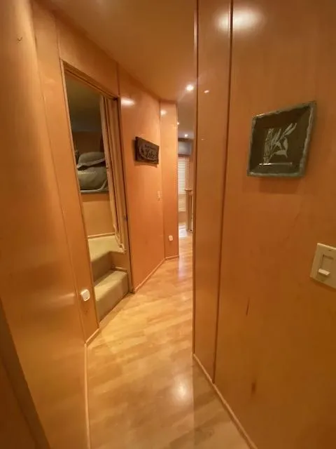 Slide: The Image of 2007 Sharpe 18 x 84 Houseboat interior hallway with wooden paneling and soft lighting. - 22