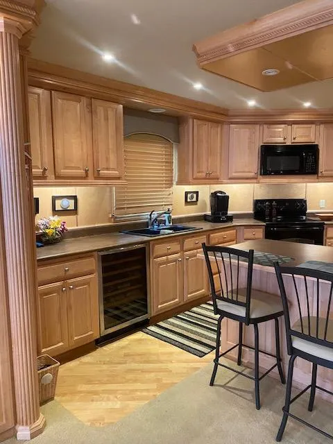 Slide: The Image of 2007 Sharpe houseboat kitchen with wooden cabinets, black appliances, and a central island. - 8