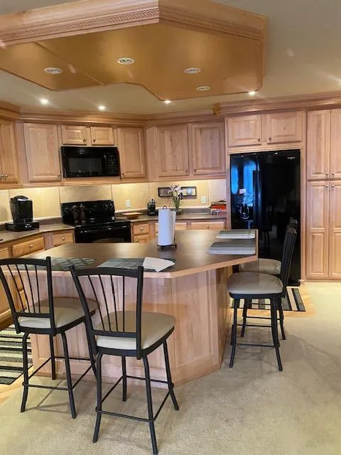 Slide: The Image of Kitchen interior of 2007 Sharpe 18 x 84 Houseboat with wooden cabinets and island. - 9