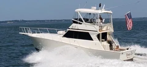 The Image of 1989 Viking 41 Convertible yacht cruising on open water with American flag. - 0