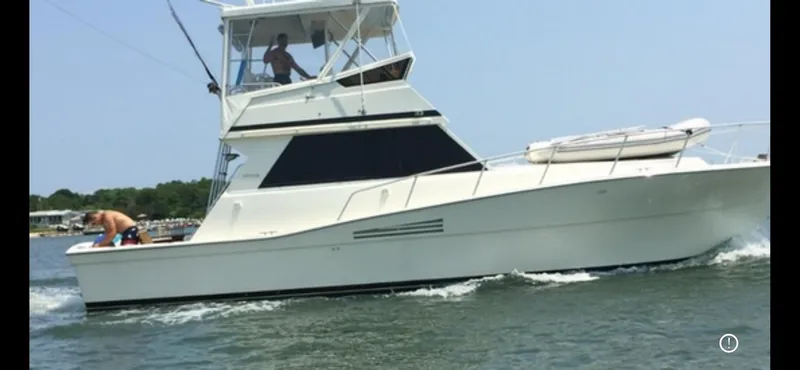 Slide: The Image of 1989 Viking 41 Convertible yacht cruising on open water, featuring a sleek white design. - 1