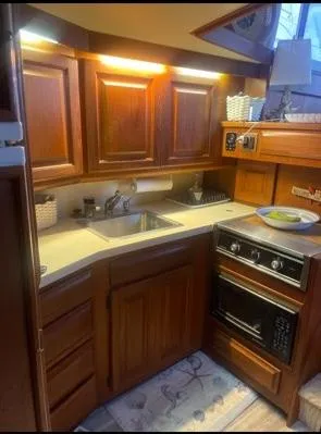 Slide: The Image of 1989 Viking 41 Convertible yacht kitchen with wooden cabinets, sink, and stove. - 10