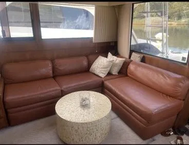 Slide: The Image of 1989 Viking 41 Convertible yacht interior with brown leather sofa and round table. - 7