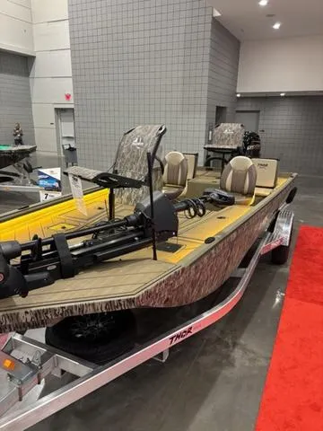 Slide: The Image of 2025 Thor LH1900 DLX Side Console boat with Baystar steering, displayed indoors on a red carpet. - 11