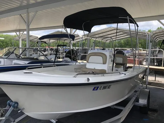 Slide: The Image of 2018 Key West 1720CC boat with canopy, parked on a trailer under a shelter. - 1
