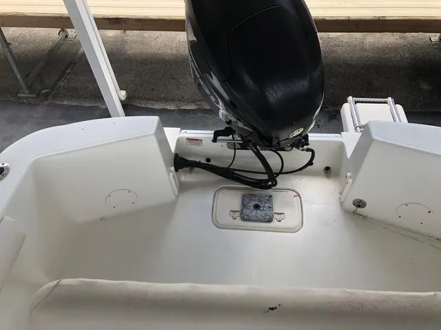 Slide: The Image of 2009 Mako 204 Center Console boat parked near vehicles under a cloudy sky. - 14