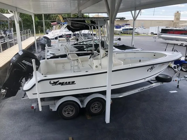 Slide: The Image of 2009 Mako 204 Center Console boat on trailer, parked under a canopy. - 16