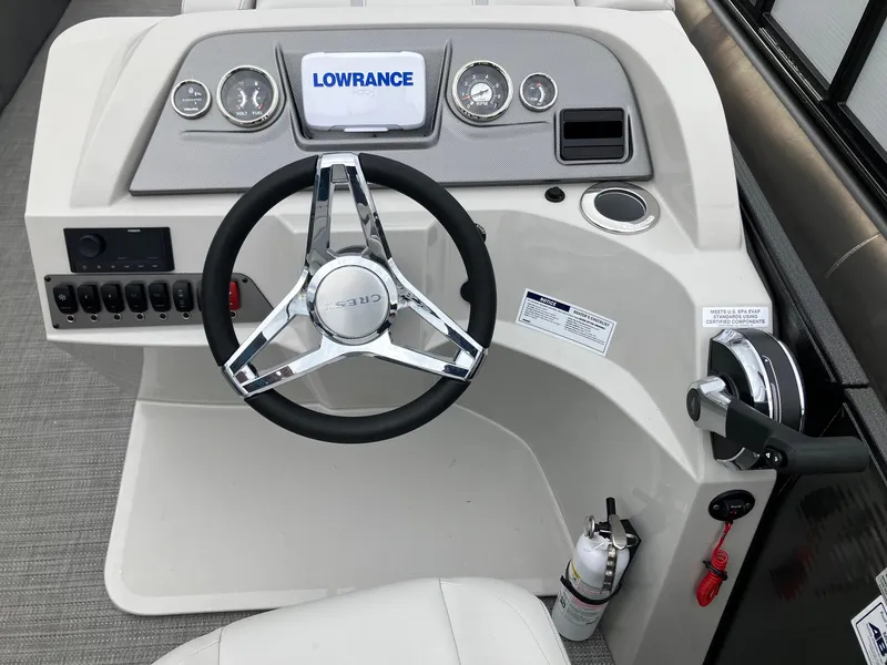 Slide: The Image of 2024 Crest 240 SLSC Classic LX boat dashboard with steering wheel and Lowrance display. - 7