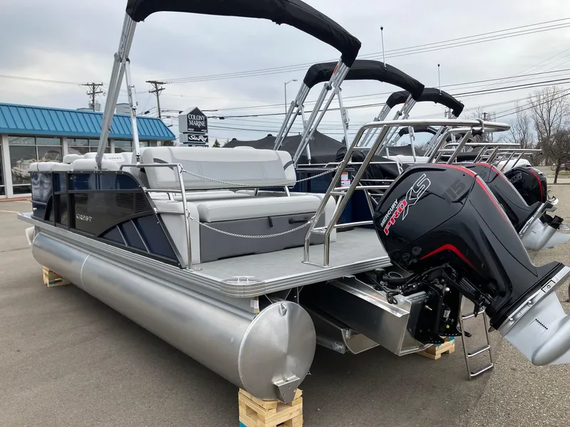 Slide: The Image of 2023 Crest 220 SLC Classic LX pontoon boat with outboard motor, displayed outdoors. - 2