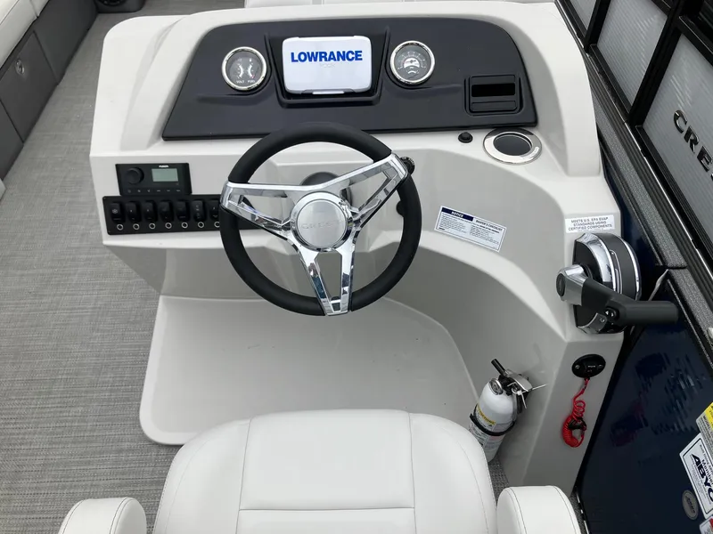 Slide: The Image of 2023 Crest 220 SLC Classic LX boat dashboard with steering wheel and Lowrance display. - 7