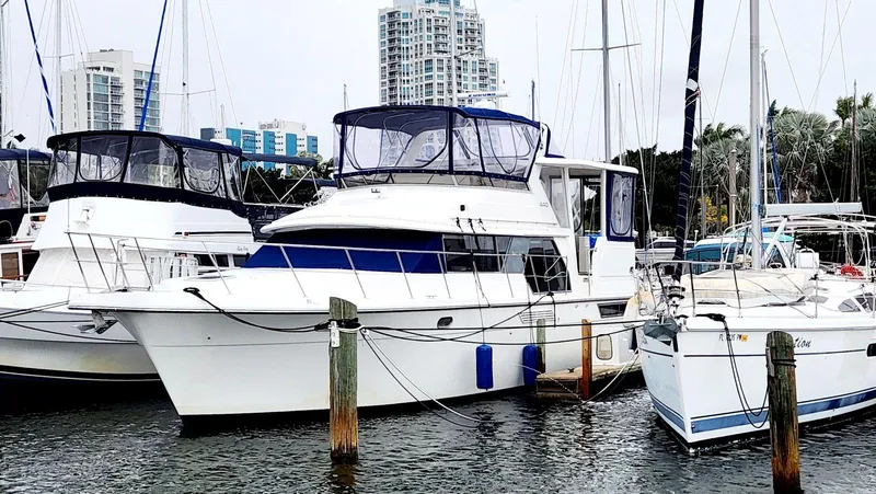 Slide: The Image of 1995 Carver 440 Aft Cabin Motor Yacht docked in marina, surrounded by other boats. - 0
