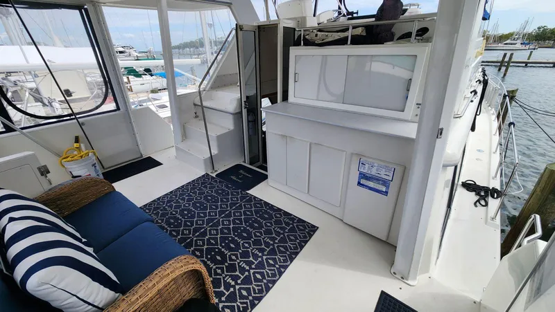 Slide: The Image of 1995 Carver 440 Aft Cabin Motor Yacht interior with seating, rug, and marina view. - 10