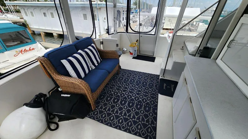Slide: The Image of 1995 Carver 440 Aft Cabin Motor Yacht interior with wicker sofa and nautical decor. - 11