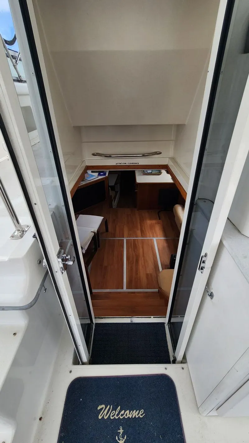 Slide: The Image of Entrance to 1995 Carver 440 Aft Cabin Motor Yacht with welcome mat and wooden interior. - 25