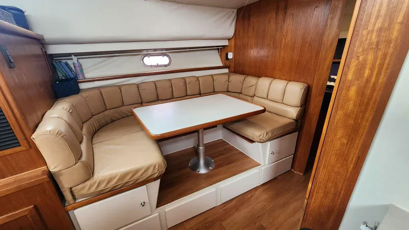 Slide: The Image of 1995 Carver 440 Aft Cabin Motor Yacht interior with cozy dining area and cushioned seating. - 29