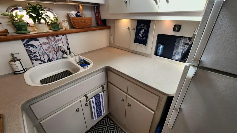 Slide: The Image of 1995 Carver 440 Aft Cabin Motor Yacht kitchen with sink, cabinets, and decor. - 31