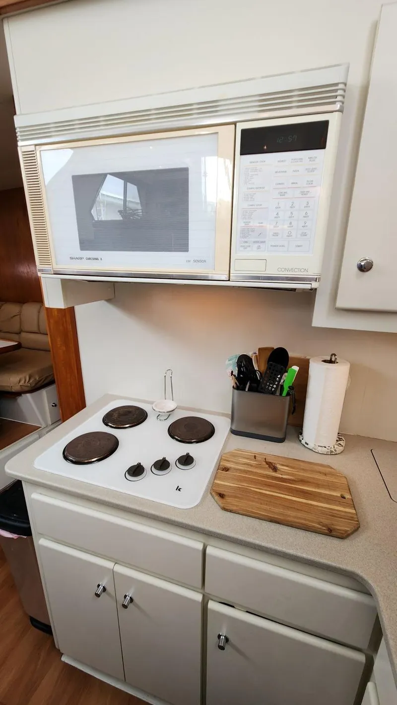 Slide: The Image of 1995 Carver 440 Aft Cabin Motor Yacht kitchen with stove, microwave, and countertop accessories. - 32