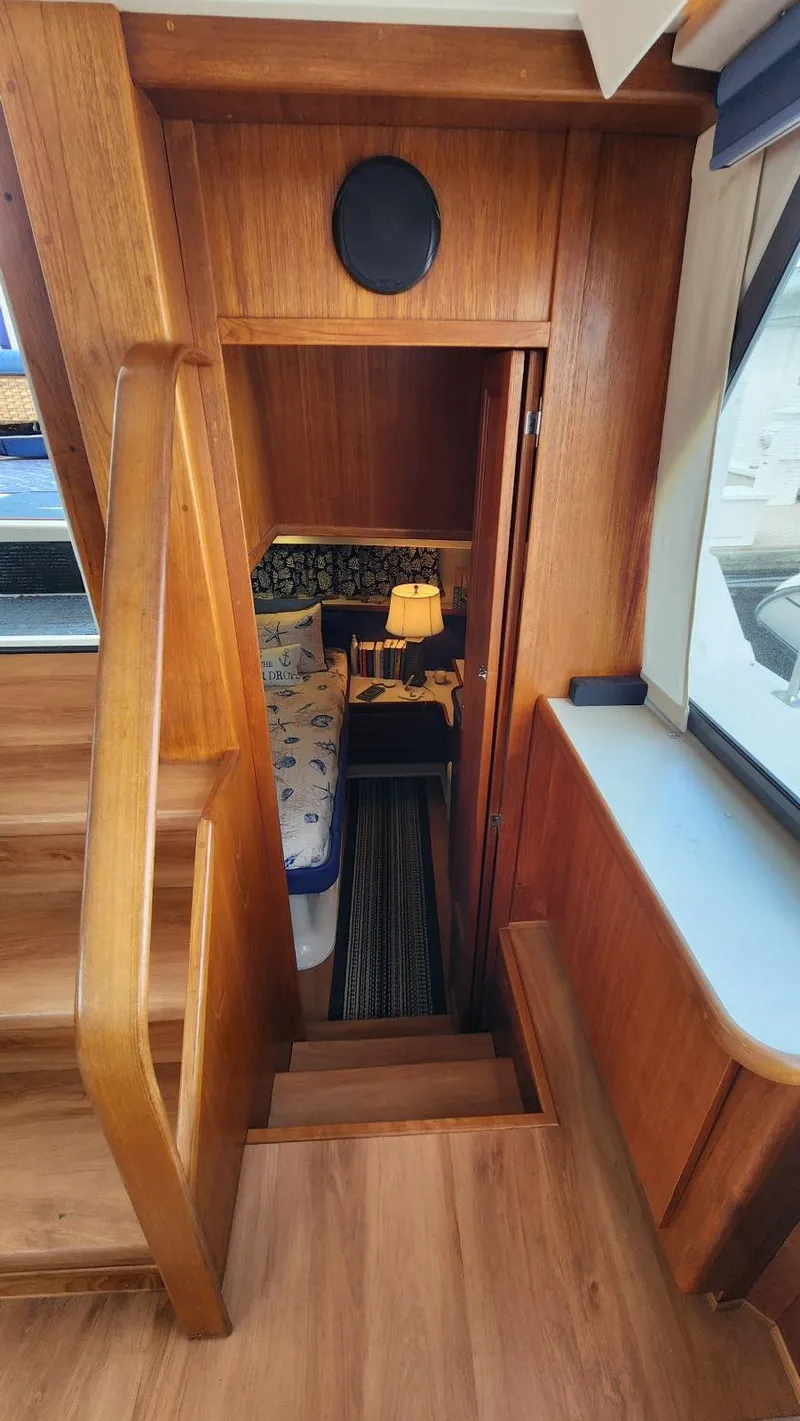 Slide: The Image of 1995 Carver 440 Aft Cabin Motor Yacht interior with wooden stairs and cozy cabin view. - 35