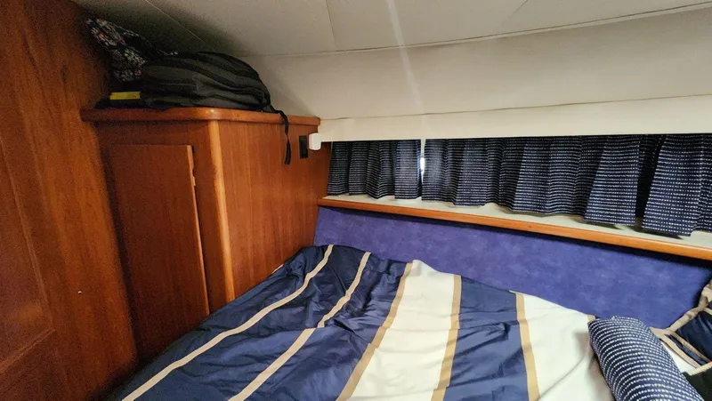 Slide: The Image of Cozy cabin interior of 1995 Carver 440 Aft Cabin Motor Yacht with striped bedding. - 44