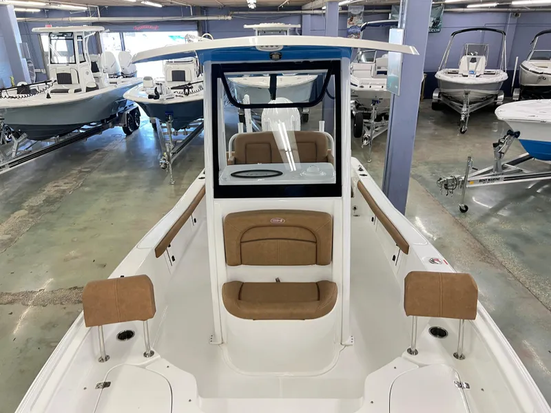Slide: The Image of 2022 Sea Hunt BX25FS boat interior with tan seating in showroom. - 11