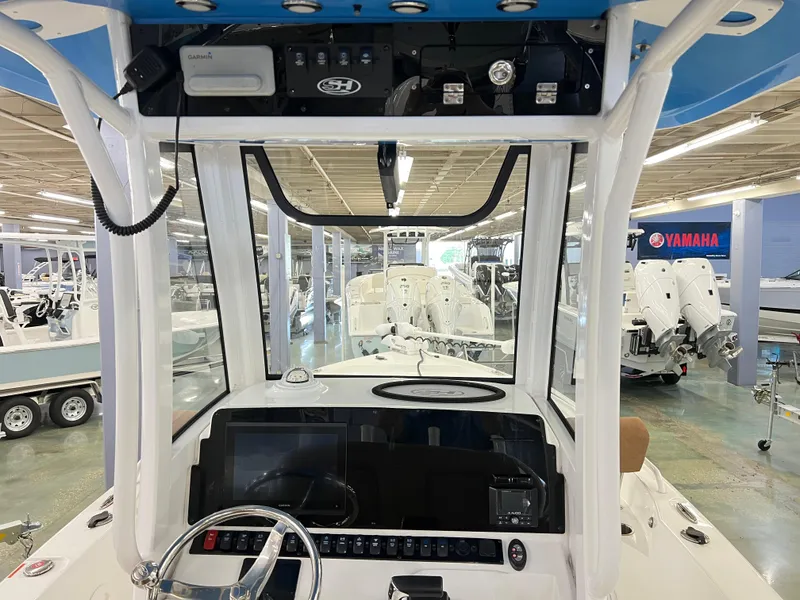 Slide: The Image of 2022 Sea Hunt BX25FS boat interior with steering wheel and control panel in showroom. - 14