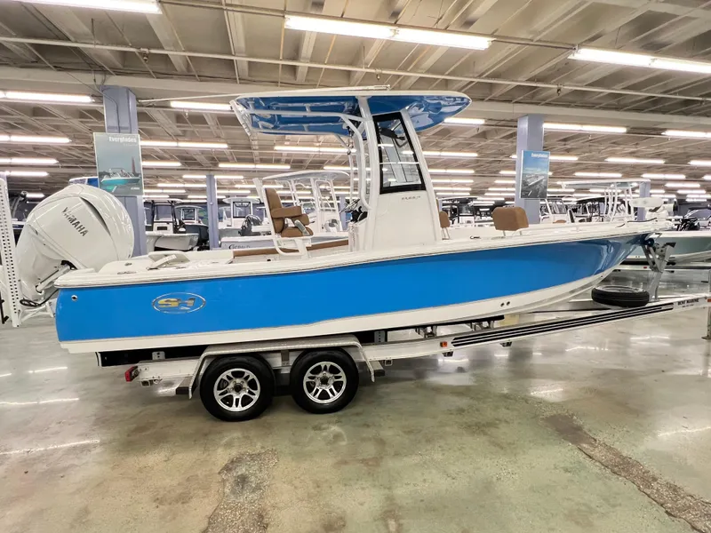 Slide: The Image of 2022 Sea Hunt BX25FS boat with blue hull on display in showroom. - 2