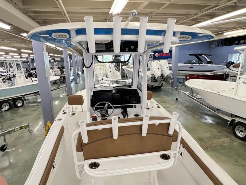 Slide: The Image of 2022 Sea Hunt BX25FS boat interior with rod holders and steering console in showroom. - 6