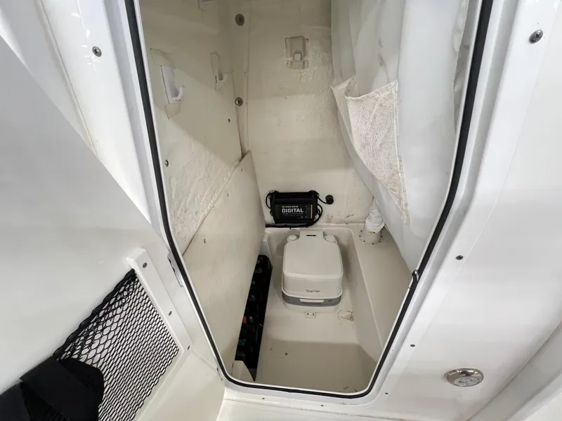 Slide: The Image of 2022 Sea Hunt BX25FS boat interior with storage compartment and portable toilet. - 8