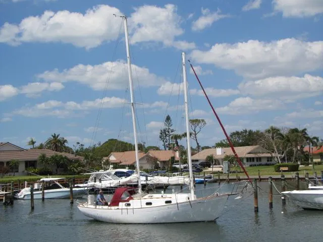 Slide: The Image of Sailboat "Lazy Jack 32" from 1974 docked in a sunny marina. - 1