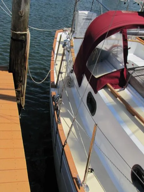 Slide: The Image of 1974 Custom Lazy Jack 32 sailboat docked with maroon canopy and wooden deck. - 11