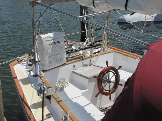 Slide: The Image of 1974 Custom Lazy Jack 32 sailboat with wooden steering wheel docked at marina. - 12
