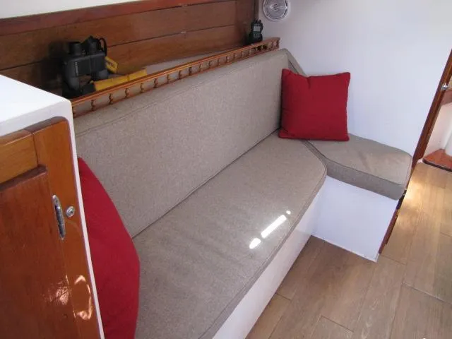 Slide: The Image of Interior of 1974 Custom Lazy Jack 32 sailboat with beige seating and red cushions. - 15