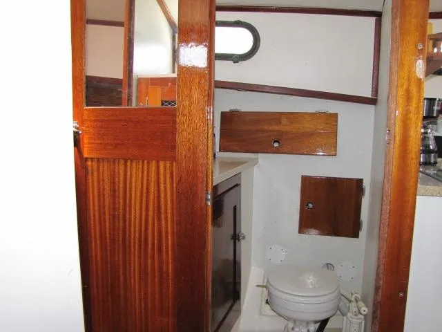 Slide: The Image of 1974 Custom Lazy Jack 32 boat interior with wooden cabinetry and compact bathroom. - 20