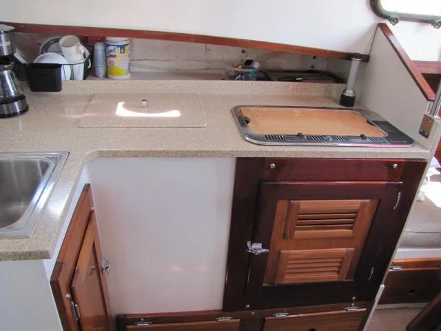 Slide: The Image of 1974 Custom Lazy Jack 32 yacht kitchen with countertop, sink, and wooden cabinets. - 22