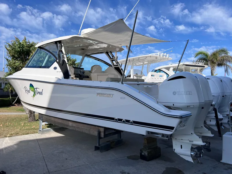 Slide: The Image of 2016 Pursuit DC 295 boat with twin Yamaha 300 engines, displayed outdoors. - 10