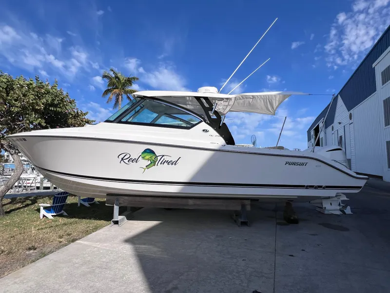 Slide: The Image of 2016 Pursuit DC 295 Dual Console boat with twin Yamaha 300 engines, docked outdoors. - 11