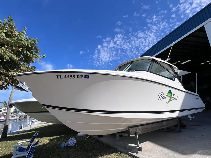 Slide: The Image of 2016 Pursuit DC 295 boat with twin Yamaha 300 engines, docked under clear blue sky. - 13