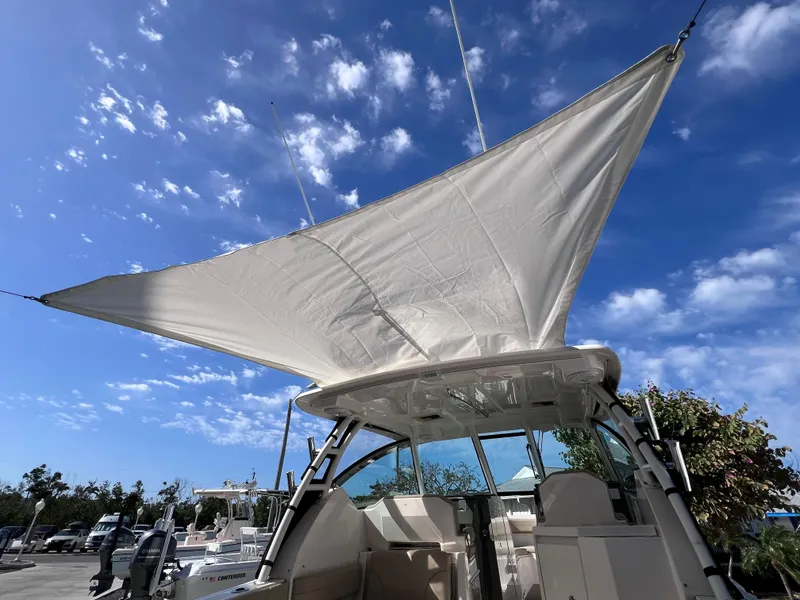 Slide: The Image of 2016 Pursuit DC 295 boat with sunshade, clear sky background. - 23