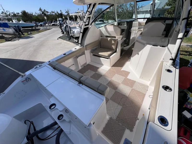 Slide: The Image of 2016 Pursuit DC 295 Dual Console boat interior with seating and clean deck. - 25